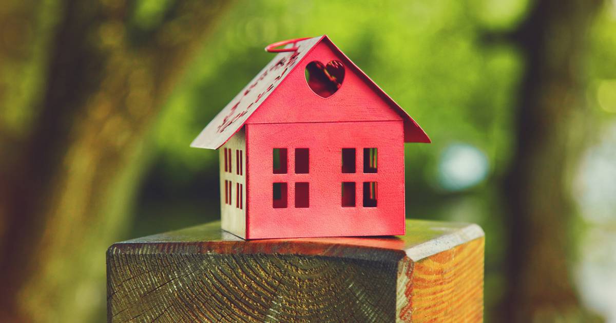 Rood model van het huis als symbool op de natuurlijke tuin achtergrond, prinsjesdag, Miljoenennota, wonen, huis, hypotheek