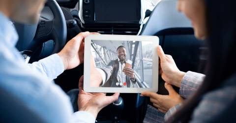 Mensen uit het bedrijfsleven maken video-oproep met online vergadering in de auto