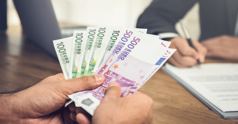 Man met briefgeld in handen en man in pak welke contract tekent